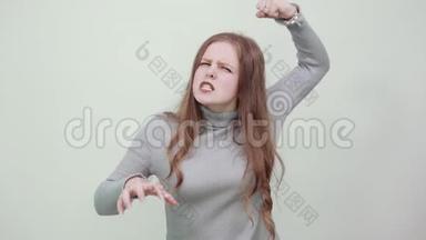 一个穿灰色毛衣的女人，一个<strong>愤怒</strong>的<strong>愤怒</strong>的女士<strong>愤怒</strong>地握着拳头
