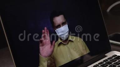 一位戴着医疗面具的视频博主正在笔记本电脑€™网络摄像头上录制广告视频。 他宣传喷喉喷雾剂