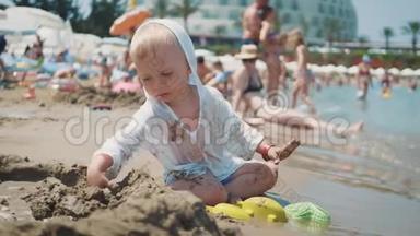 那个可爱的小男孩在海边玩沙子玩具。 孩子们在暑假在海滩度假。