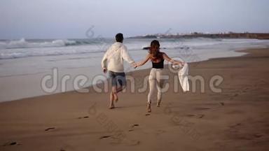 情侣们在大海边享受<strong>暑假</strong>，享受生活，在背景海洋上的风景慢动作视频中奔跑