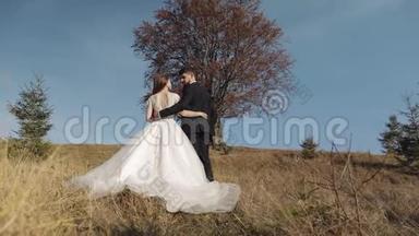 新婚夫妇。 白人新郎和新娘靠近美丽的秋树。 新婚夫妇