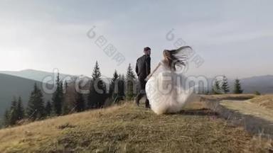 新婚夫妇。 白人新郎新娘在山坡上奔跑。 新婚夫妇