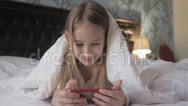 十几岁的女孩在床上玩社交网络上的平板电脑。