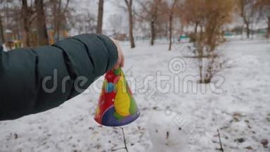 快乐女孩在冬季公园堆雪人。 寒假和圣诞节的概念。
