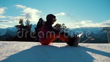 坐在山顶上享受山景的滑雪板女孩。 雪山上的运动女人。 美丽动人