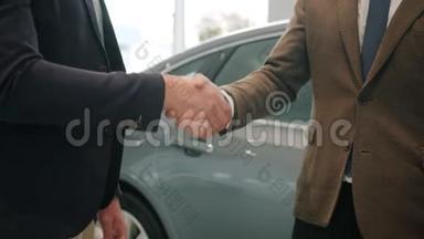 慢动作特写男士握手在汽车陈列室拿钥匙fo
