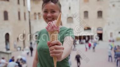 快乐的黑发女孩，戴着眼镜，手里拿着粉红色的雪糕筒和意大利冰淇淋