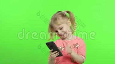 小女孩用智能手机。 有智能手机的儿童制作照片和自拍