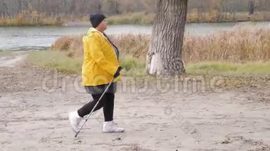 在秋天的森林里做<strong>北欧</strong>行走的高级妇女。 在秋天的小径上进行<strong>北欧</strong>步行比赛。 退休人士健康