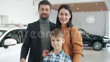 在汽车陈列室里，父母和孩子站在一起的欢快的肖像