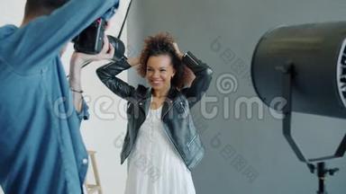 摄影师在摄影棚里拍摄快乐的非裔美国女孩模特