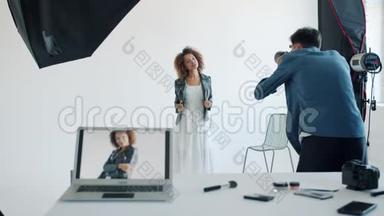 一位美丽的年轻女士在摄影棚与摄影师合影时摆<strong>姿势拍照</strong>
