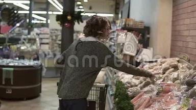 高加索女人开着手推车穿过超市的食品部门，用potatos挑选两个袋子