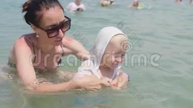 妈妈带着一个小<strong>妩媚的</strong>儿子沐浴大海，家庭幸福.. 小妈妈教小男孩游泳。 家庭休息