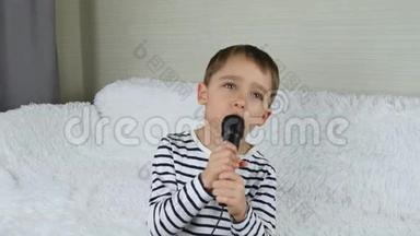 一个快乐的小男孩唱成玩具麦克风，想象自己是一个歌手。 儿童音乐和游戏、音乐