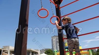 一个快乐的孩子在阳光明媚的夏日`带着戒指在孩子们的游乐场玩耍。 幼儿`户外游戏..