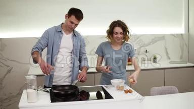 偶然的情侣一起在家庭厨房<strong>做饭</strong>。 积极的漂亮女人打碎鸡蛋，英俊的丈夫<strong>做饭</strong>