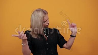 穿黑色衣服的女孩穿着黄色时髦的女人跳舞，举起食指