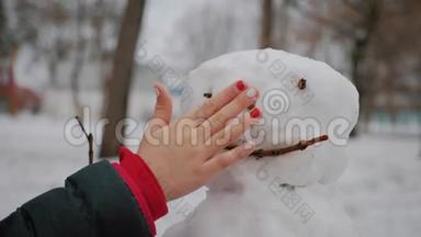 快乐女孩在冬季公园<strong>堆雪人</strong>。 寒假和<strong>圣诞节</strong>的概念。