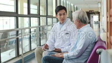 一位亚洲医生在医院走廊上和老人说话
