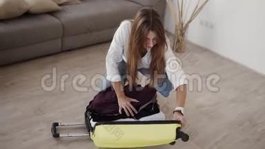 准备旅行包。 年轻女子<strong>收拾行李</strong>，绝望地试图关上手提箱，关上拉链。