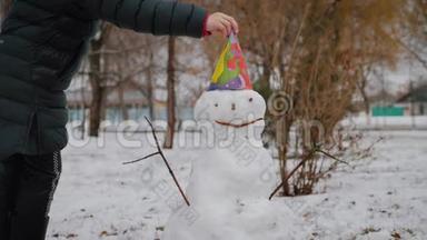 快乐女孩在冬季公园<strong>堆雪人</strong>。 寒假和圣诞节的概念。