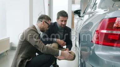 专业销售人员在<strong>展厅</strong>向客户展示车轮时谈论新车型
