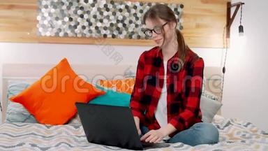 一个年轻的女人，可以是年轻的老师、学生或作家，坐在大双人床上写着笔记本电脑