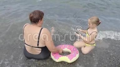 祖母带着一个<strong>小</strong>可爱的孙女在海里洗澡，家庭幸福。 祖母教的<strong>小东西</strong>
