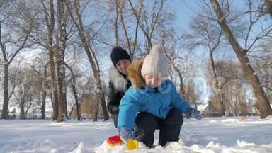小男孩和他妈妈在雪地公园玩得很<strong>开心</strong>。 快乐的家庭在冬天玩雪。 活跃的冬<strong>季</strong>游戏。