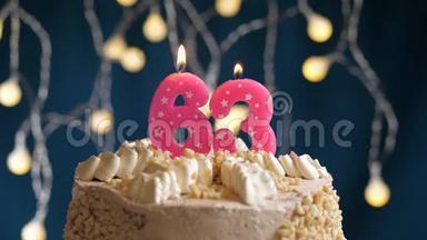 生日蛋糕，有<strong>63</strong>个数字粉红色燃烧蜡烛在蓝色的背景上。 蜡烛吹灭了。 慢速运动和特写镜头