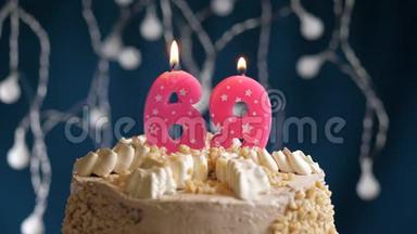 <strong>生日蛋糕</strong>上有69个<strong>数字</strong>的粉红色燃烧蜡烛在蓝色的背景上。 蜡烛吹灭了。 慢速运动和特写镜头