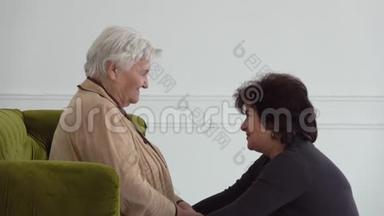 美丽的女人在白屋子里和年迈的母亲说话