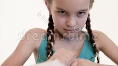 女孩扎着辫子，棕色的眼睛愤怒地在白色的背景上撕扯玩具熊。