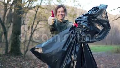 一位美丽的志愿者女人手里拿着垃圾袋的肖像。 开展一次清理森林的运动
