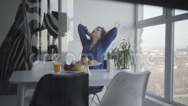 摄影棚拍摄的快乐的成年白种人女人早上在室内吃早餐。 微笑着的黑发女人