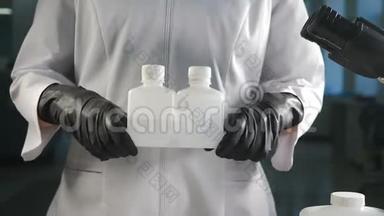 现代<strong>实验</strong>室理念。 戴黑手套的科学家用显微镜观察白色塑料瓶<strong>容器</strong>