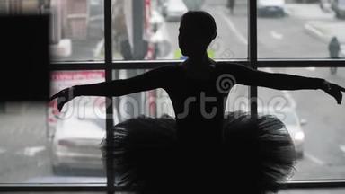 城市背景上<strong>芭蕾</strong>舞女演员的<strong>剪影</strong>是一支动人的<strong>舞蹈</strong>。 穿着黑色的图图和黑角鞋。