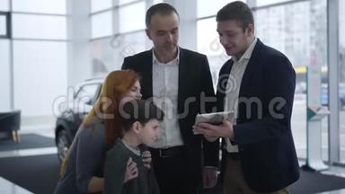 高加索家族在展厅和汽车经销商交谈。 丈夫、妻子和小男孩在经销商处选择新车