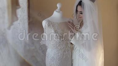 美丽可爱的新娘穿着睡衣和面纱。 结婚礼服。 慢动作