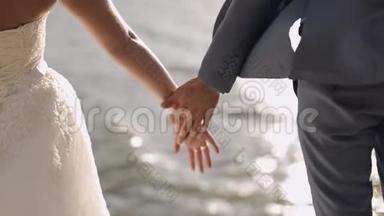 新婚<strong>夫妇</strong>站在海边。 他们互相<strong>握手</strong>。 新郎和新娘