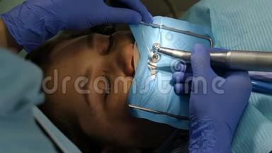 牙科行业概念。 暗影。 在诊所工作的女牙医的特写镜头。 后景。 化妆品牙科