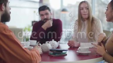 在咖啡馆里，一群年轻的朋友在<strong>后台</strong>聊天，把智能<strong>手机</strong>放在桌子上。 快乐的人