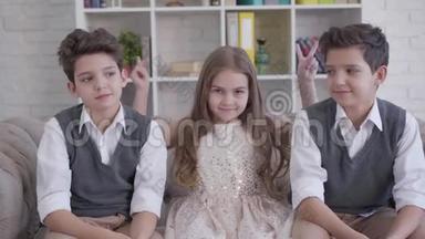 三个积极的高加索儿童坐在沙发上竖起大拇指的肖像。 <strong>双胞胎兄弟</strong>和小可爱