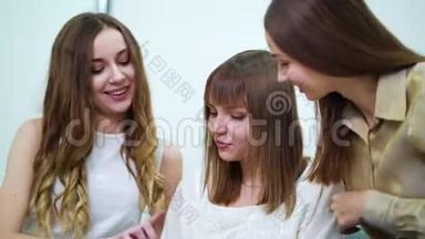三个美女在美容院看时装目录