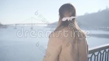 阳光明媚的秋日，年轻的高加索女人从桥上望着河。 积极的黑发<strong>胖妞</strong>