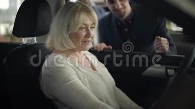 漂亮成熟的白种人女人坐在<strong>司机</strong>`座位上和汽车经销商交谈的肖像。 自信的<strong>老</strong>太太