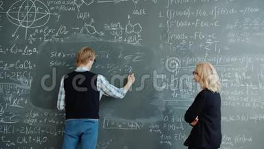 学生和老师在教室里用黑板书写公式