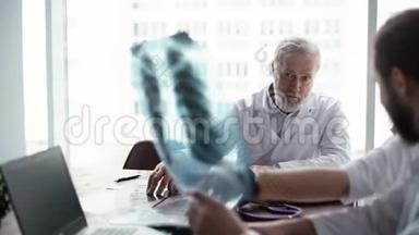 老年男医生和留胡子男医生分析x射线图像