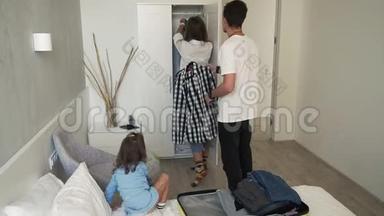快乐的白种人一家人和他们的小女儿度假回来，在新房子里打开黄色的手提箱